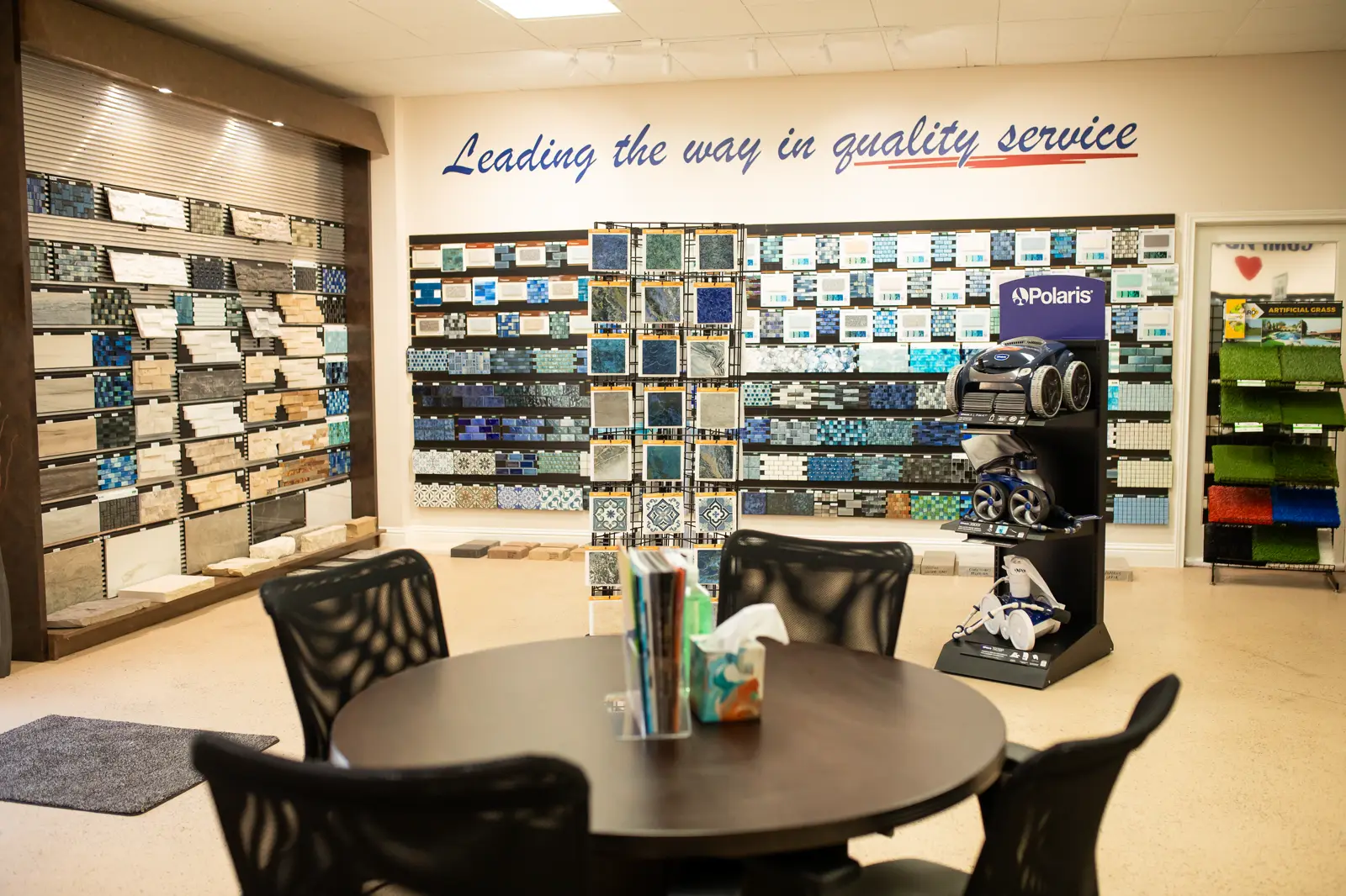 Wide view of the U.S. Pool Professionals showroom in Rockwall with tile displays and a consultation table