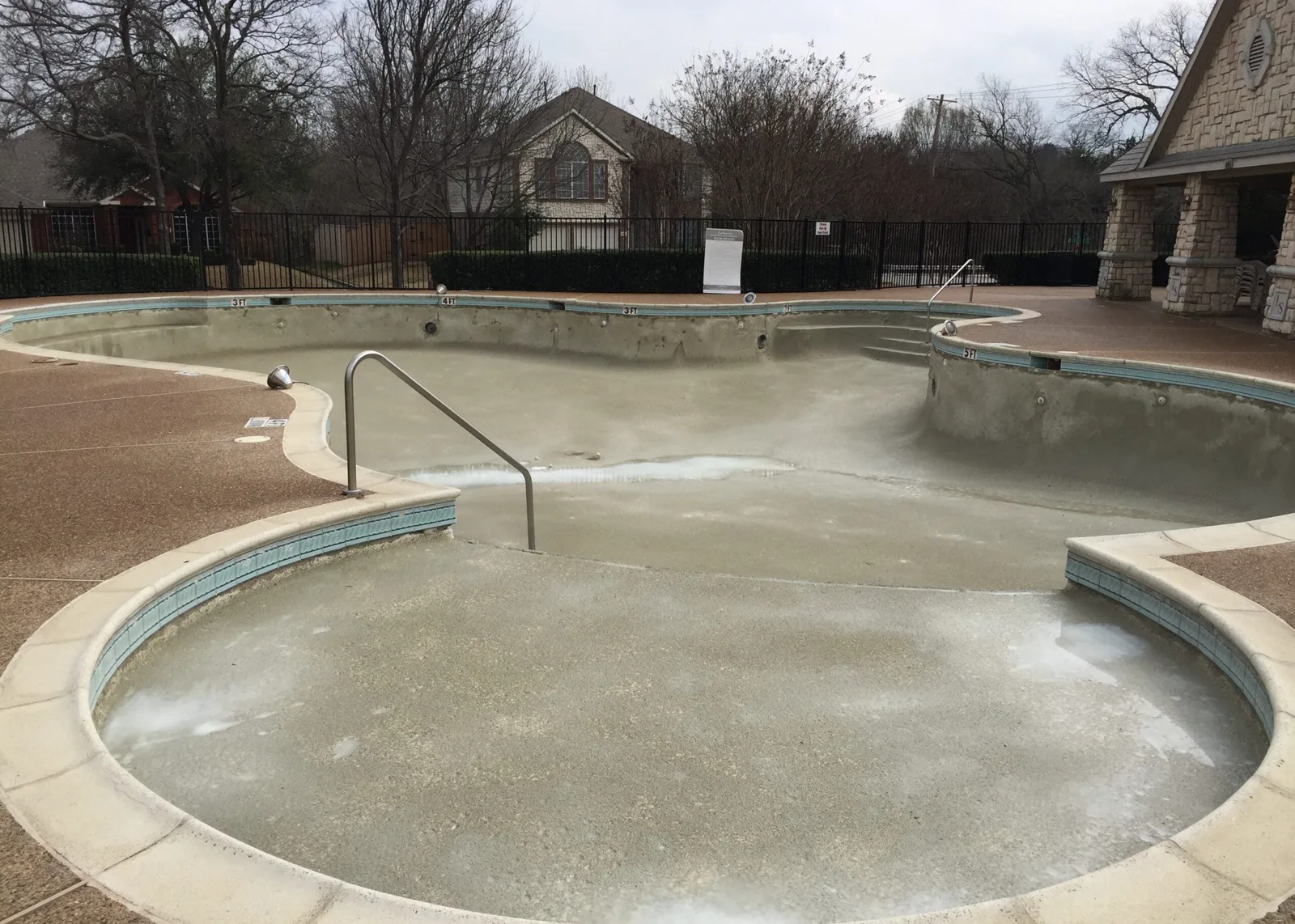 Community pool shell before renovation and resurfaced pool filled with clear blue water after