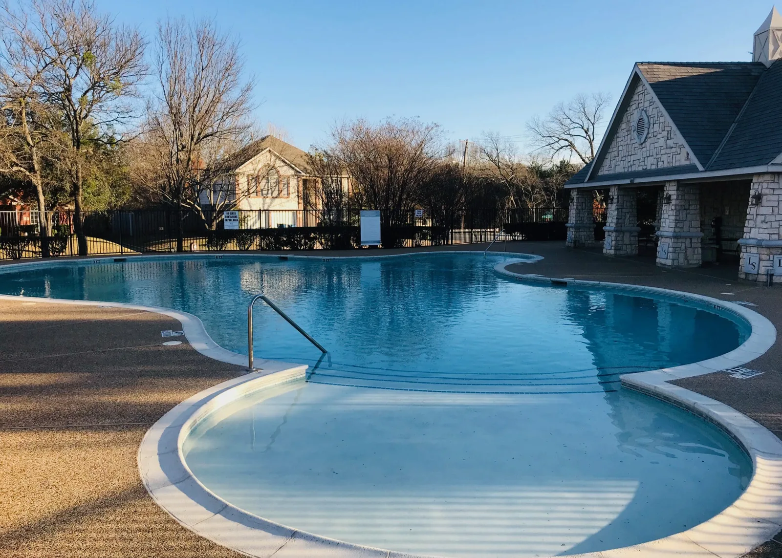 Community pool shell before renovation and resurfaced pool filled with clear blue water after
