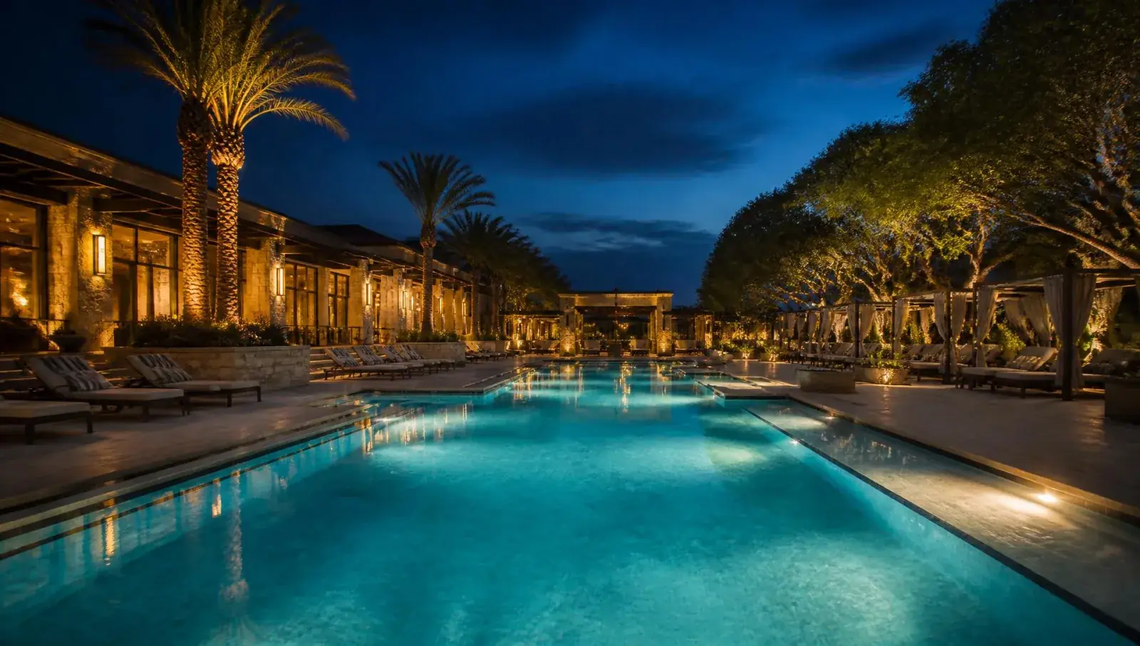 Cinematic dusk view of a beautifully lit commercial resort pool in North Texas